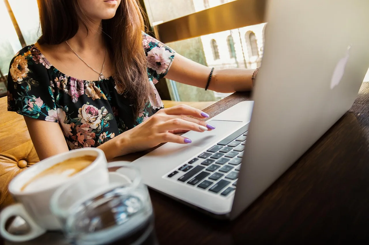Frau arbeitet in einem Café an einem Laptop